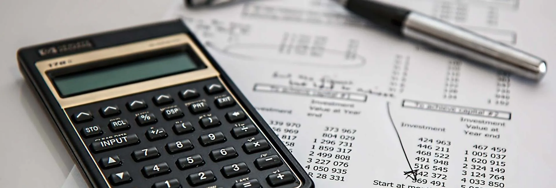 A pocket calculator laying on top of accounting printouts